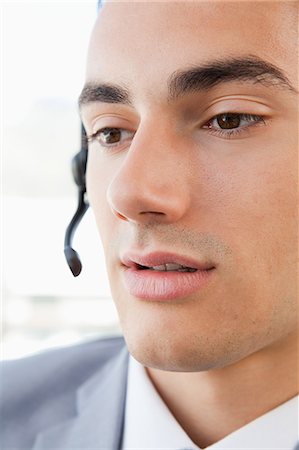 Gros plan d'un homme de parler avec un casque d'écoute dans un bureau lumineux Photographie de stock - Premium Libres de Droits, Code: 6109-06005547