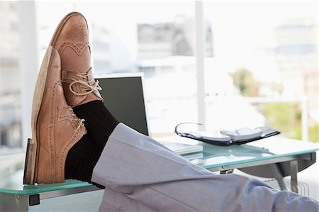 Businessman feet on his desk in a bright office Stock Photo - Premium Royalty-Free, Code: 6109-06005562