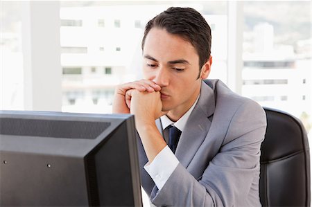 Bored businessman in front of his computer in a bright office Stock Photo - Premium Royalty-Free, Code: 6109-06005527