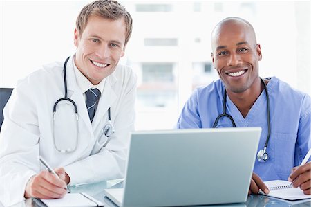 simsearch:6109-06005907,k - Smiling doctors together with laptop Stock Photo - Premium Royalty-Free, Code: 6109-06005884