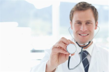 simsearch:6109-06005907,k - Smiling doctor using his stethoscope Stock Photo - Premium Royalty-Free, Code: 6109-06005891