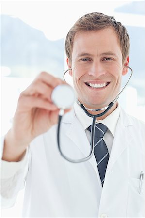 simsearch:6109-06005907,k - Smiling doctor examining with his stethoscope Stock Photo - Premium Royalty-Free, Code: 6109-06005894