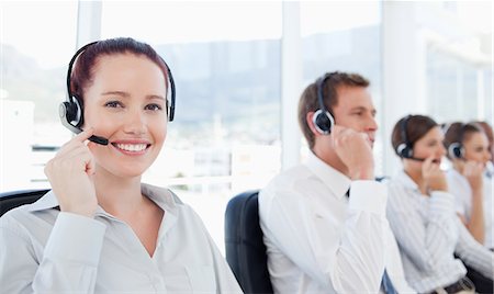 Smiling young telephone help desk employee at work Stock Photo - Premium Royalty-Free, Code: 6109-06005806