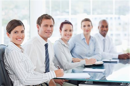 sales team - Side view of smiling young salespeople sitting at a table Stock Photo - Premium Royalty-Free, Code: 6109-06005837