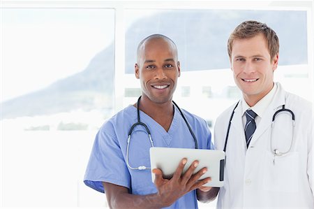 simsearch:6109-06005907,k - Smiling and standing doctors using tablet computer together Stock Photo - Premium Royalty-Free, Code: 6109-06005905