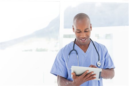 simsearch:6109-06005907,k - Smiling male doctor using tablet computer Stock Photo - Premium Royalty-Free, Code: 6109-06005908