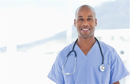 simsearch:6109-06005907,k - Smiling male doctor standing in front of a window Stock Photo - Premium Royalty-Free, Code: 6109-06005912