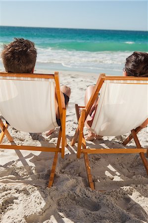 summer beach beauty - Vue arrière d'un couple en prenant un bain de soleil sur les chaises longues face à l'océan Photographie de stock - Premium Libres de Droits, Code: 6109-06006147