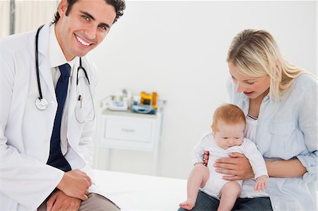 Médecin de sexe masculin souriant avec une mère et son bébé Photographie de stock - Premium Libres de Droits, Code: 6109-06006450