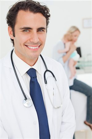 doctors girls hospital - Smiling young doctor with mother and her baby behind him Stock Photo - Premium Royalty-Free, Code: 6109-06006492