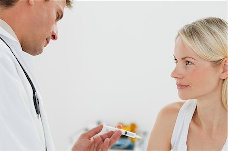 Side view of male doctor giving an immunization to his patient Stock Photo - Premium Royalty-Free, Code: 6109-06006423