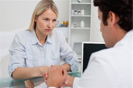 patient talking to doctor in office - Worried looking woman seeing her doctor Stock Photo - Premium Royalty-Free, Code: 6109-06006709