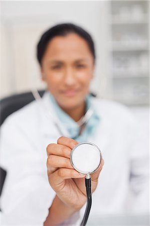 simsearch:6109-06006928,k - Stethoscope being held by a doctor sitting in her office Stock Photo - Premium Royalty-Free, Code: 6109-06006926
