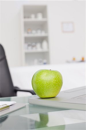 Delicious green apple placed on a laptop in a medical office Stock Photo - Premium Royalty-Free, Code: 6109-06006930