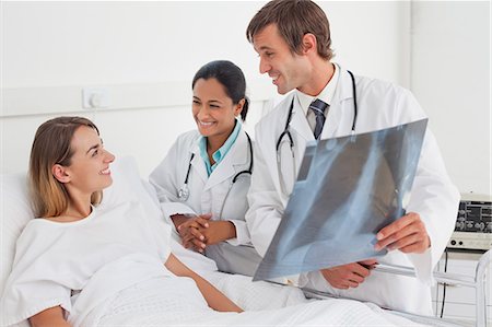 simsearch:6109-06006928,k - Smiling doctors announcing good news to a patient while showing a chest x-ray Stock Photo - Premium Royalty-Free, Code: 6109-06007043
