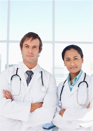 simsearch:6109-06006928,k - Serious doctors looking at the camera while standing upright with arms crossed Stock Photo - Premium Royalty-Free, Code: 6109-06007020