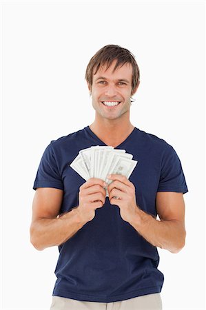 fingers holding - Fan of bank notes held by a smiling man against a white background Stock Photo - Premium Royalty-Free, Code: 6109-06007163