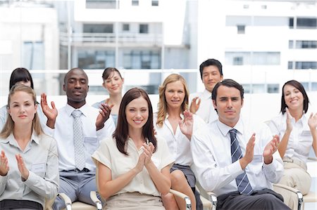 sales team - A group of colleagues look ahead and applaud as they sit next to each other Stock Photo - Premium Royalty-Free, Code: 6109-06007212