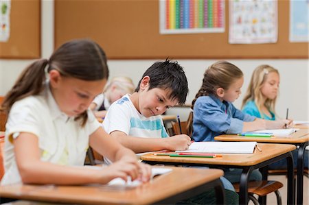 simsearch:6109-06007455,k - Side view of elementary students doing their exercises Stock Photo - Premium Royalty-Free, Code: 6109-06007458