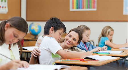 schoolboy - Side view of teacher helping her student Stock Photo - Premium Royalty-Free, Code: 6109-06007464