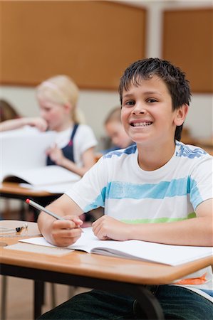 simsearch:6109-06007455,k - Smiling young schoolboy at his desk Stock Photo - Premium Royalty-Free, Code: 6109-06007433