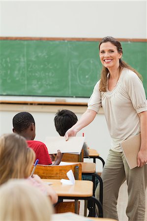 Elementary teacher handing out exercise books Stock Photo - Premium Royalty-Free, Code: 6109-06007540