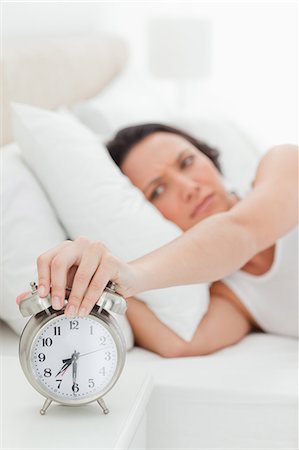 Close-up of an alarm clock being turned off by a woman Stock Photo - Premium Royalty-Free, Code: 6109-06194168