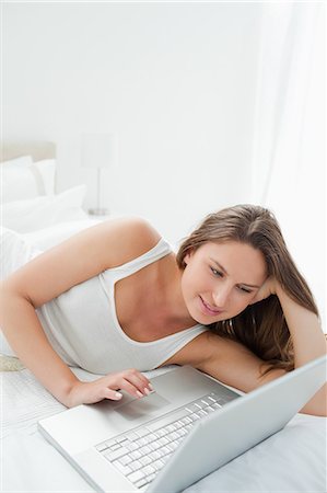 personal - Close-up of a woman lying on her bed while using a laptop Stock Photo - Premium Royalty-Free, Code: 6109-06194463