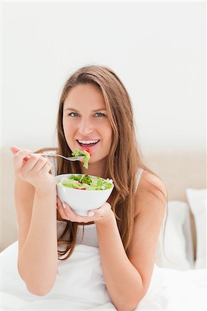 eco friendly home - Close-up of a young woman eating a bowl of salad Stock Photo - Premium Royalty-Free, Code: 6109-06194423
