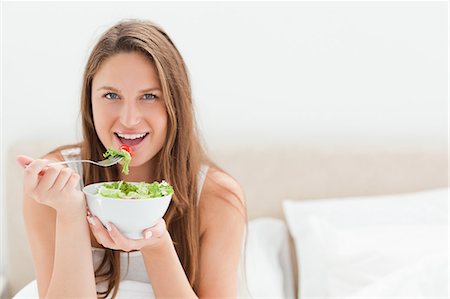eco friendly home - Young woman eating a bowl of salad Stock Photo - Premium Royalty-Free, Code: 6109-06194422