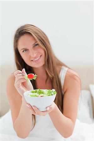 eco friendly home - Close-up of a woman with a bowl of salad offering a tomato to eat Stock Photo - Premium Royalty-Free, Code: 6109-06194427