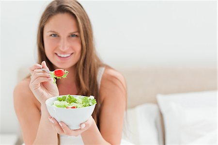 eco friendly home - Woman with a bowl of salad offering a tomato to eat Stock Photo - Premium Royalty-Free, Code: 6109-06194426