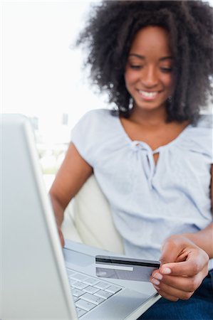 Close-up of a happy fuzzy hair woman buying online Stock Photo - Premium Royalty-Free, Code: 6109-06194611