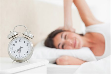 simsearch:6109-06194878,k - Brunette waking up by her alarm ringing Stock Photo - Premium Royalty-Free, Code: 6109-06194890