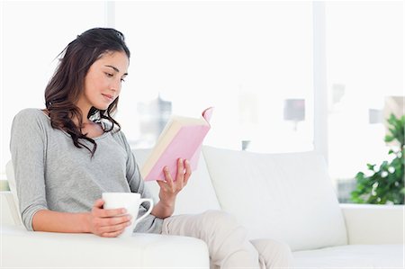Young woman reading a book with a coffee Stock Photo - Premium Royalty-Free, Code: 6109-06194810