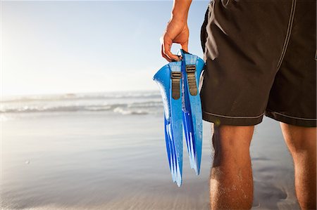 fins - Rear view of a man holding fins Stock Photo - Premium Royalty-Free, Code: 6109-06195372