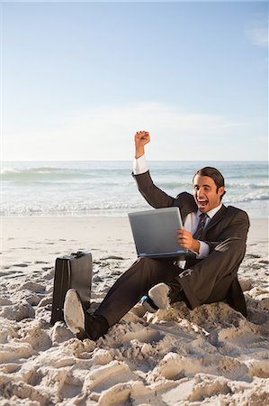 Successful businessman sitting on the beach while smiling Stock Photo - Premium Royalty-Free, Code: 6109-06195337