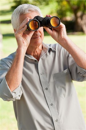 Old man looking through a binoculars Stock Photo - Premium Royalty-Free, Code: 6109-06195426