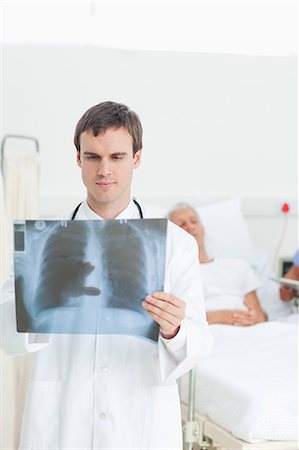 patient (medical) - Médecin, observant une analyse aux rayons x en face de lui Photographie de stock - Premium Libres de Droits, Code: 6109-06195709