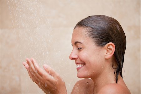 Side view of smiling woman enjoying a shower Stock Photo - Premium Royalty-Free, Code: 6109-06195736