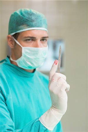 simsearch:400-06734297,k - Surgeon holding a surgical scalpel Stock Photo - Premium Royalty-Free, Code: 6109-06195899