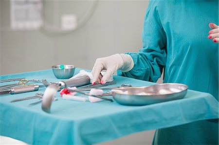 Surgeon taking surgical tools on a surgical tray Stock Photo - Premium Royalty-Free, Code: 6109-06195995