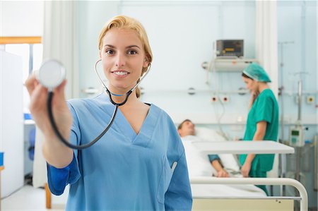 Blonde nurse holding a stethoscope next to a bed Stock Photo - Premium Royalty-Free, Code: 6109-06195927