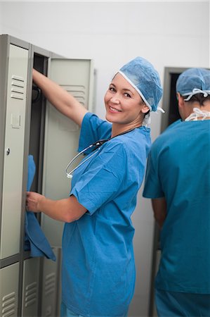 Smiling surgeon taking something in a locker Stock Photo - Premium Royalty-Free, Code: 6109-06196051