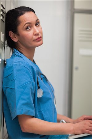 store change rooms - Female surgeon sitting in a locker room with a laptop Stock Photo - Premium Royalty-Free, Code: 6109-06196060