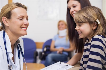 doctor in waiting room - Doctor and girl smiling while sitting in a waiting room Stock Photo - Premium Royalty-Free, Code: 6109-06196091