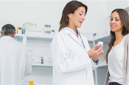 patients close up - Pharmacist talking to a customer while holding pills Stock Photo - Premium Royalty-Free, Code: 6109-06196164