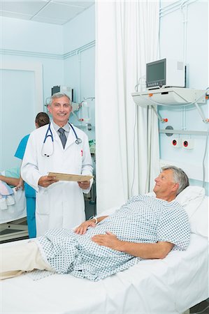 simsearch:6109-06196363,k - Smiling doctor with a happy patient in a bed ward Stock Photo - Premium Royalty-Free, Code: 6109-06196255