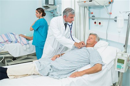 simsearch:6109-06196363,k - Male doctor auscultating a male patient in a bed ward Stock Photo - Premium Royalty-Free, Code: 6109-06196259
