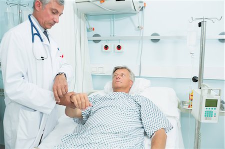 simsearch:6109-06196363,k - Doctor measuring the pulse of a patient Stock Photo - Premium Royalty-Free, Code: 6109-06196264